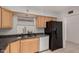 Galley kitchen featuring granite counters, wood cabinets, tile flooring, and black refrigerator at 5055 E Enid Ave, Mesa, AZ 85206