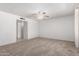 Spacious living room with neutral carpeting, a ceiling fan, and a doorway leading to other rooms at 5055 E Enid Ave, Mesa, AZ 85206