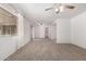 Open living room with plush carpeting, neutral walls, a ceiling fan, and natural light from sliding glass doors at 5055 E Enid Ave, Mesa, AZ 85206