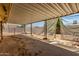 This covered patio has a concrete floor and is partially covered by a mesh sun shade at 5055 E Enid Ave, Mesa, AZ 85206