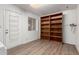 This room features wood floors, an exit door, a window, and a tall, built-in wooden bookshelf at 5055 E Enid Ave, Mesa, AZ 85206