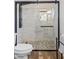 Modern tiled shower with a sleek glass enclosure, pebble floor, and black hardware in a stylish bathroom at 526 W Kings Ave, Phoenix, AZ 85023