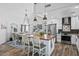 Modern kitchen and dining area featuring wood floors, pendant lighting, a wine refrigerator, and stainless steel appliances at 526 W Kings Ave, Phoenix, AZ 85023