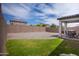 Large backyard with a covered patio, stone landscaping, and green grass at 5726 W Atlantis Way, Phoenix, AZ 85043