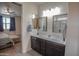 Bathroom with dual vanities, dark cabinets, and mirrors, open to the main bedroom at 5726 W Atlantis Way, Phoenix, AZ 85043