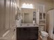 Bathroom with a large mirror, a dark vanity, and a cabinet above the toilet at 5726 W Atlantis Way, Phoenix, AZ 85043
