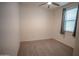 The bedroom has wood-look flooring, a ceiling fan, and a window with grey curtains at 5726 W Atlantis Way, Phoenix, AZ 85043