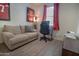 This room features light wood-look floors, a comfy couch, and sporty decor at 5726 W Atlantis Way, Phoenix, AZ 85043