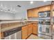 Beautiful kitchen features stainless steel appliances, warm wood cabinetry, and granite countertops at 5757 W Eugie Ave # 1076, Glendale, AZ 85304