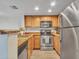 Charming kitchen features stainless steel appliances, warm wood cabinetry, and granite countertops at 5757 W Eugie Ave # 1076, Glendale, AZ 85304