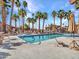 Community pool surrounded by palm trees under a blue sky at 5757 W Eugie Ave # 1076, Glendale, AZ 85304