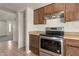 Kitchen featuring stainless steel oven, pantry, and wooden cabinets at 6611 W Kingston Ln, Glendale, AZ 85306