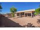 A large gravel backyard with a covered patio and small trees provides an outdoor oasis at 6984 S Newport Ct, Chandler, AZ 85249