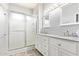 Bathroom featuring double sinks with white cabinets, granite counters and a glass shower at 6984 S Newport Ct, Chandler, AZ 85249