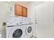 Bright laundry area features a Samsung washer and dryer, wooden cabinets, and two white laundry baskets at 6984 S Newport Ct, Chandler, AZ 85249