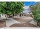 Backyard featuring stone paver path, large tree and covered patio at 705 W Country Estates Ave, Gilbert, AZ 85233