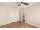 Bright bedroom features hardwood floors, a ceiling fan, a closet and an ensuite bathroom at 705 W Country Estates Ave, Gilbert, AZ 85233