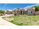 Home exterior featuring arched entry, two-car garage, and manicured lawn at 705 W Country Estates Ave, Gilbert, AZ 85233