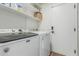 Laundry room with Maytag washer and dryer, open shelves, and white door at 705 W Country Estates Ave, Gilbert, AZ 85233