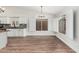 Open layout area with wood floors connecting to a kitchen and modern fixtures at 705 W Country Estates Ave, Gilbert, AZ 85233