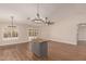 Open-concept living area features wood floors, modern lighting, and a stylish island with gray cabinets at 705 W Country Estates Ave, Gilbert, AZ 85233