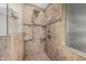 Walk-in shower featuring decorative tile, shower head, glass door, and built-in shelving at 705 W Country Estates Ave, Gilbert, AZ 85233