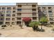 Building entrance with a red awning, mature landscaping and neutral paint at 7840 E Camelback Rd # 110, Scottsdale, AZ 85251