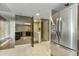 View into kitchen with mirrored wall, stainless refrigerator, and laundry room access at 7840 E Camelback Rd # 110, Scottsdale, AZ 85251
