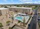 Aerial view of a community pool with retractable covers, lounge chairs, and mature landscaping at 7840 E Camelback Rd # 110, Scottsdale, AZ 85251