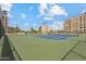 Full tennis court surrounded by community buildings under a blue sky with scattered clouds at 7840 E Camelback Rd # 110, Scottsdale, AZ 85251