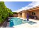 Refreshing pool area with a blue umbrella, a waterfall feature, lush hedges, and travertine pavers at 903 E Jacob St, Chandler, AZ 85225