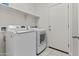 Well-lit laundry room with a modern washer and dryer, convenient shelving, and access to the outdoors at 9303 W Oregon Ave, Glendale, AZ 85305