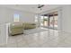 Bright living room with neutral tile flooring, tufted sofas, ceiling fan, and sliding glass door to the backyard at 9303 W Oregon Ave, Glendale, AZ 85305