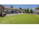 Lush backyard with a large lawn, patio with dining set, and mature trees, perfect for outdoor enjoyment at 9466 E Laurel Ln, Scottsdale, AZ 85260
