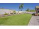 Lush backyard with artificial grass, hammock, desert landscaping, and a block privacy fence at 9466 E Laurel Ln, Scottsdale, AZ 85260