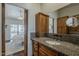 Bathroom with granite countertop, wood cabinets, and backyard view from bedroom at 9466 E Laurel Ln, Scottsdale, AZ 85260