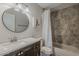 Bathroom with a white sink and vanity, round mirror, and tub with tiled surround at 9466 E Laurel Ln, Scottsdale, AZ 85260