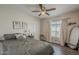 Bedroom featuring wood-look floors, a ceiling fan, and bright window with curtains at 9466 E Laurel Ln, Scottsdale, AZ 85260