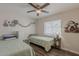 Bedroom featuring twin beds, wood-look floors, a ceiling fan, and bright window at 9466 E Laurel Ln, Scottsdale, AZ 85260