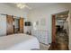 Bright bedroom with barn door to bathroom, white dresser, and stylish decor at 9466 E Laurel Ln, Scottsdale, AZ 85260