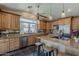 Well-lit kitchen features custom wood cabinets, granite counters, and stainless steel appliances at 9466 E Laurel Ln, Scottsdale, AZ 85260