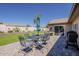 Backyard patio area with outdoor dining table, landscaping, and a grill at 9466 E Laurel Ln, Scottsdale, AZ 85260