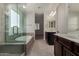 The primary bathroom features a glass-enclosed shower, a soaking tub, and double sinks with dark cabinetry at 9548 E Rainbow Ave, Mesa, AZ 85212