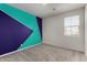 The bedroom features vibrant accent walls, plush carpeting, and a window offering ample natural light at 9548 E Rainbow Ave, Mesa, AZ 85212