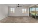 Spacious living room featuring carpeted floors, two large windows and a sliding glass door to backyard at 9548 E Rainbow Ave, Mesa, AZ 85212