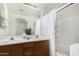 Bathroom with double sinks, wood cabinets, a large mirror, and a shower at 10239 W Via Del Sol -- # 400, Peoria, AZ 85383