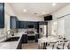 Modern kitchen features navy cabinets, stainless steel appliances, white countertops and a dining table at 10239 W Via Del Sol -- # 400, Peoria, AZ 85383