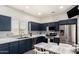 A modern kitchen boasts navy cabinets, subway tile backsplash, stainless steel appliances, and a cozy breakfast nook at 10239 W Via Del Sol -- # 400, Peoria, AZ 85383