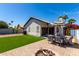Backyard patio with shade umbrella, seating, fire pit, and lush landscaping at 1279 N Blackstone Dr, Chandler, AZ 85224