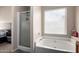 Bright bathroom featuring a shower and separate soaking tub under a window at 1279 N Blackstone Dr, Chandler, AZ 85224